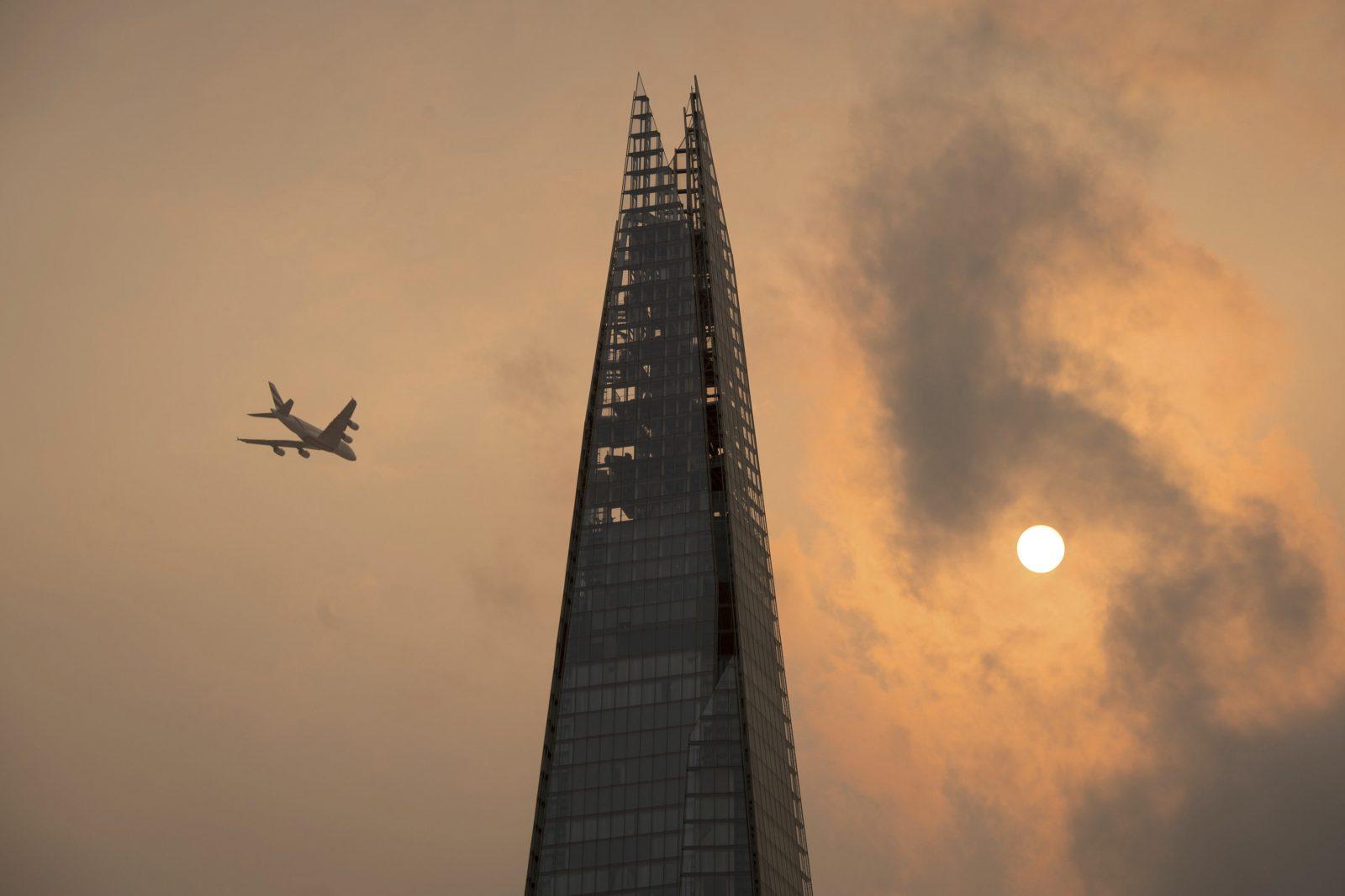 A plane flies past the Shard in central London, as the sky takes on an unusual orange colour caused by Hurricane Ophelia Monday Oct. 16, 2017. The unusual occurrence was due to the remnants of the hurricane dragging in tropical air and dust from the Sahara. (Dominic Lipinski/PA via AP)